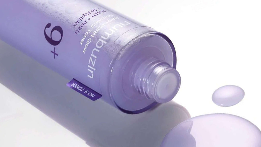 Flaskor och förpackningar av Anua Heartleaf 77% Soothing Toner arrangerade konstnärligt med skuggor och ljusspel på en ljus bakgrund.