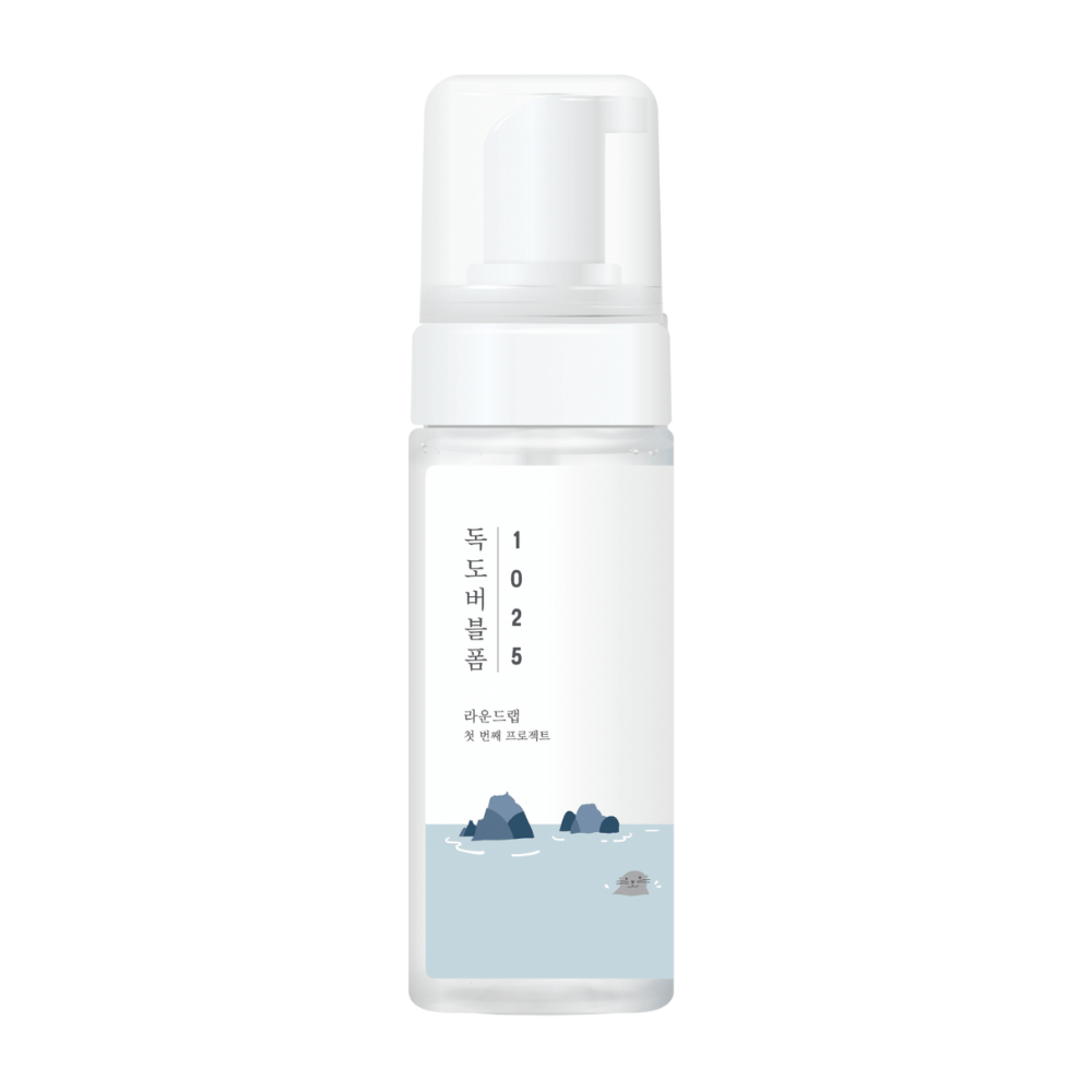 1025 Dokdo Bubble Foam" est un produit nettoyant pour le visage de ROUND LAB, emballé dans un flacon pompe blanc au design simple et épuré, orné de texte et d'illustrations minimalistes de paysages marins. 