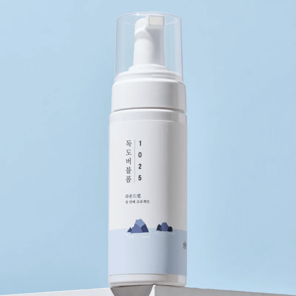  Le produit est un "1025 Dokdo Bubble Foam" de ROUND LAB, emballé dans un flacon pompe blanc au design minimaliste. Il est destiné au nettoyage en profondeur du visage sans irritation.