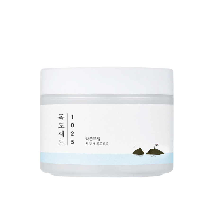 Un pot blanc fermé de 1025 Dokdo Pads avec un design simple et un motif marin sur l'étiquette, sur un fond blanc.