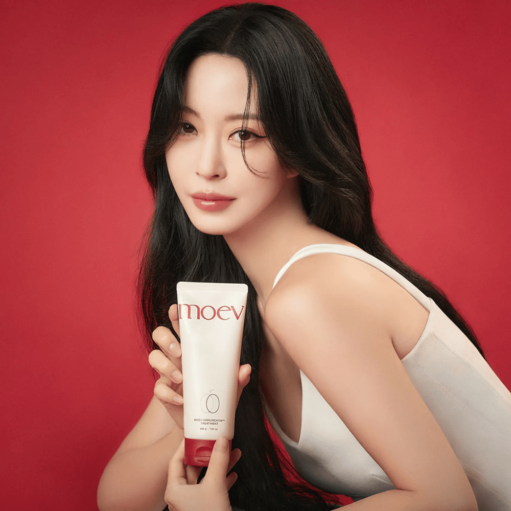 Femme aux cheveux longs et brillants tenant MOEV Annurcatin Treatment – soin capillaire coréen qui nourrit, renforce et fait briller avec des ingrédients naturels.