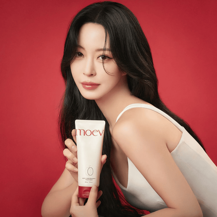 Femme aux cheveux longs et brillants tenant MOEV Annurcatin Treatment – soin capillaire coréen qui nourrit, renforce et fait briller avec des ingrédients naturels.