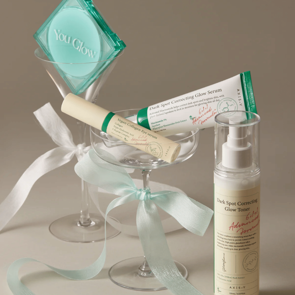 Image de Kit de soin de la peau de AXIS-Y avec sérum pour les yeux, sérum et toner – élégamment disposés dans un verre à cocktail avec un ruban de soie, parfait pour une présentation de cadeau luxueuse.