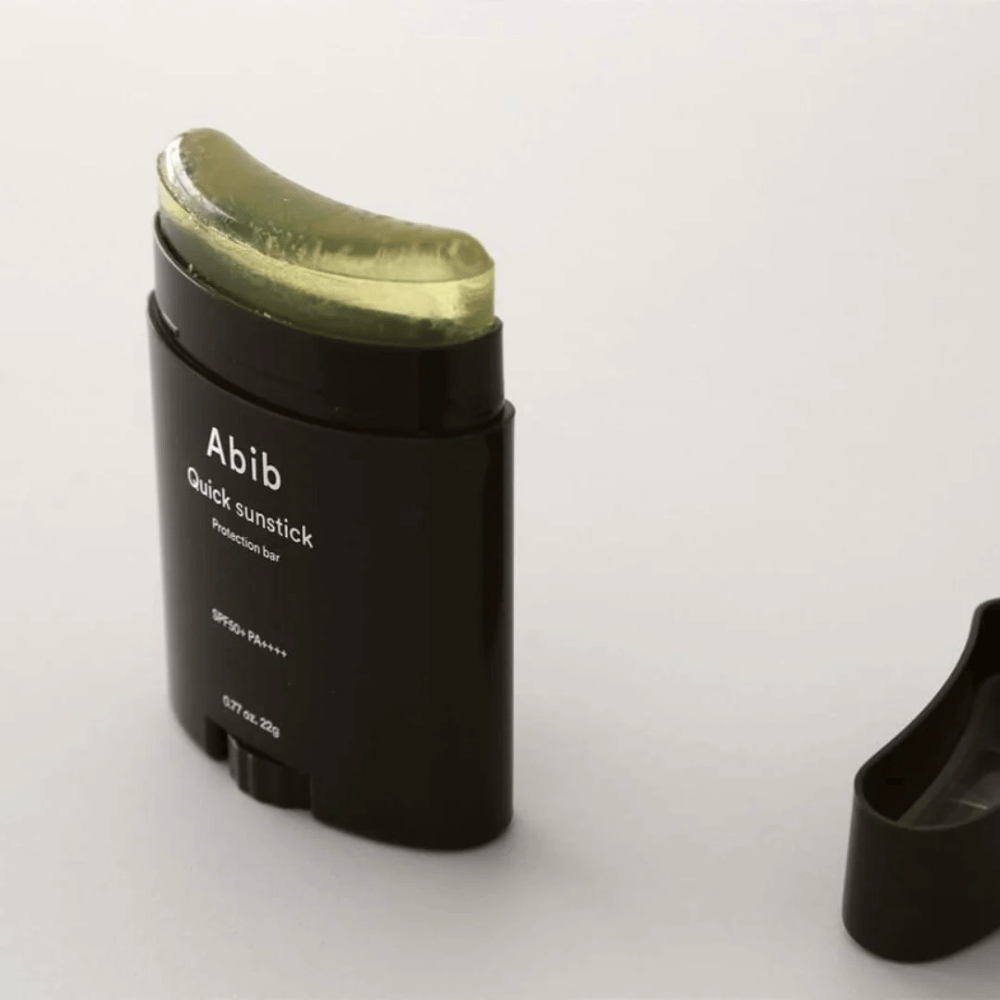 Un tube noir avec un bouchon vert, contenant Quick Sunstick Protection Bar SPF50+ PA++++ 22g de Abib pour la protection solaire.