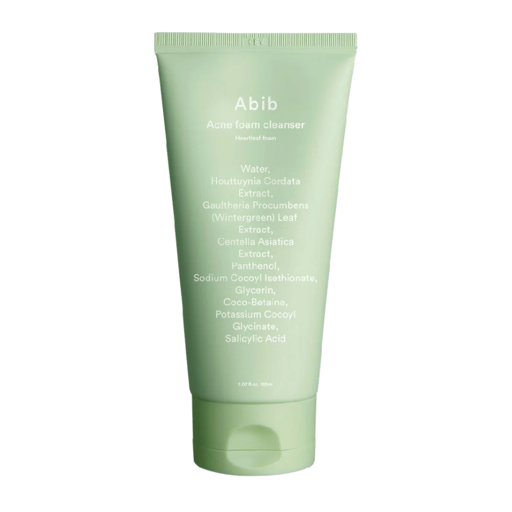 Tube verte avec Abib Acne Foam Cleanser Heartleaf Foam, montrant des ingrédients comme Houttuynia Cordata, Centella Asiatica et acide salicylique imprimés sur le devant. Le produit est debout sur un fond blanc.