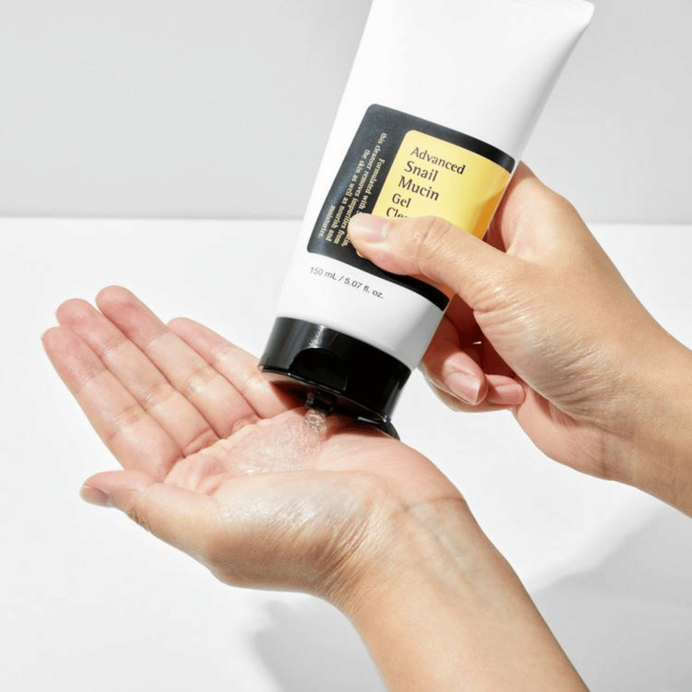 Main appliquant COSRX Advanced Snail Mucin Gel Cleanser – nettoyant gel doux avec mucine d'escargot qui nettoie en profondeur et préserve l'équilibre hydrique de la peau.