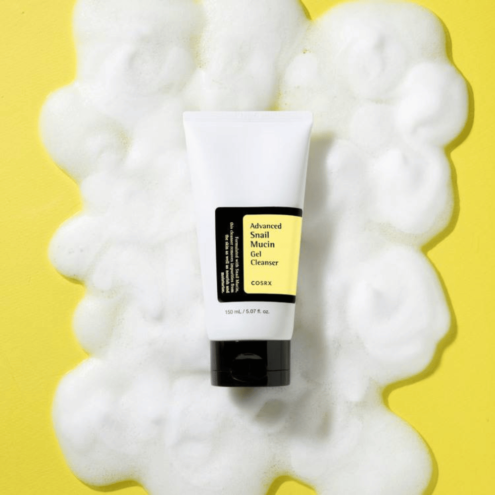 COSRX Advanced Snail Mucin Gel Cleanser 150 ml entouré de mousse abondante sur fond jaune – nettoyant visage coréen doux avec mucus d'escargot pour hydratation et éclat.