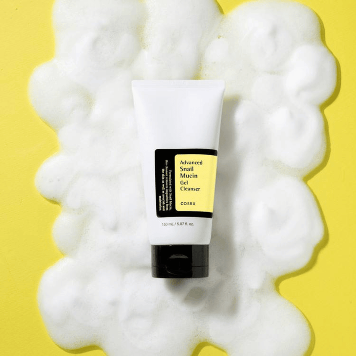 COSRX Advanced Snail Mucin Gel Cleanser 150 ml entouré de mousse abondante sur fond jaune – nettoyant visage coréen doux avec mucus d'escargot pour hydratation et éclat.