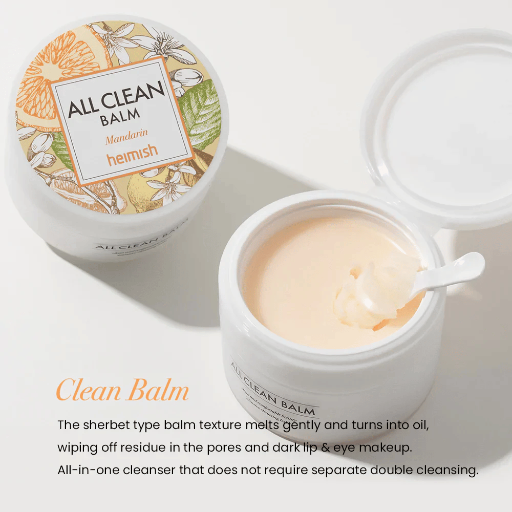 Pot ouvert de Heimish All Clean Balm Mandarin avec une cuillère remuant le baume nettoyant crémeux, avec une étiquette colorée et le texte 'Clean Balm' au premier plan.