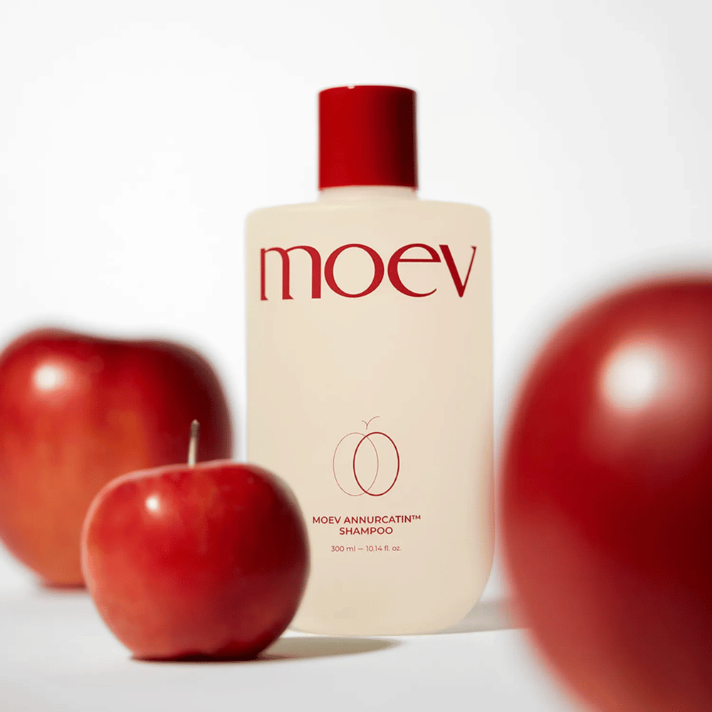 MOEV Annurcatin Shampoo placé parmi les pommes rouges – inspiré par les antioxydants de la pomme Annurca qui donnent des cheveux plus forts, plus sains et plus brillants.