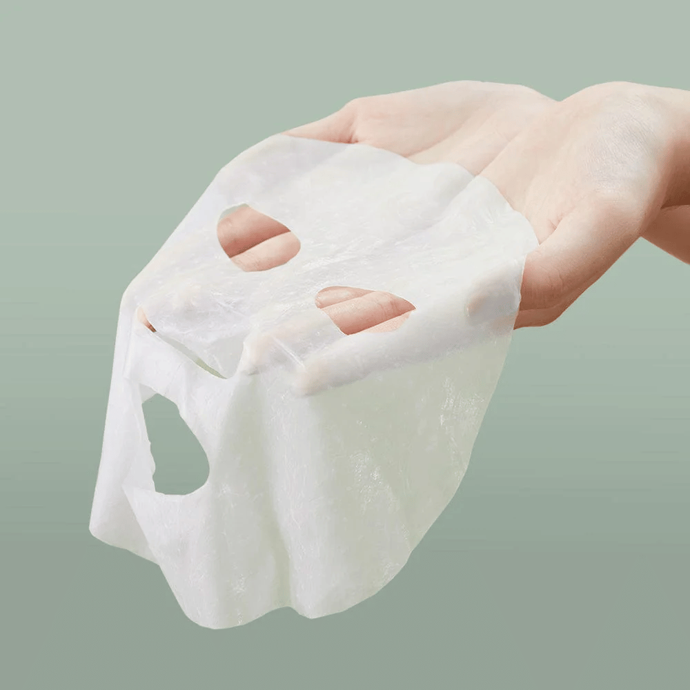 La main d'une personne tenant Anua Heartleaf 77% Soothing Sheet Mask.