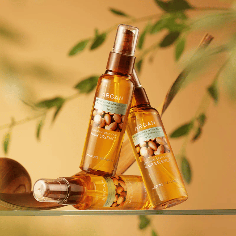 Trois bouteilles de Nature Republic Argan Essential Moisture Hair Oil avec de l'huile d'argan – nourrit, donne de l'éclat et répare les cheveux abîmés.
