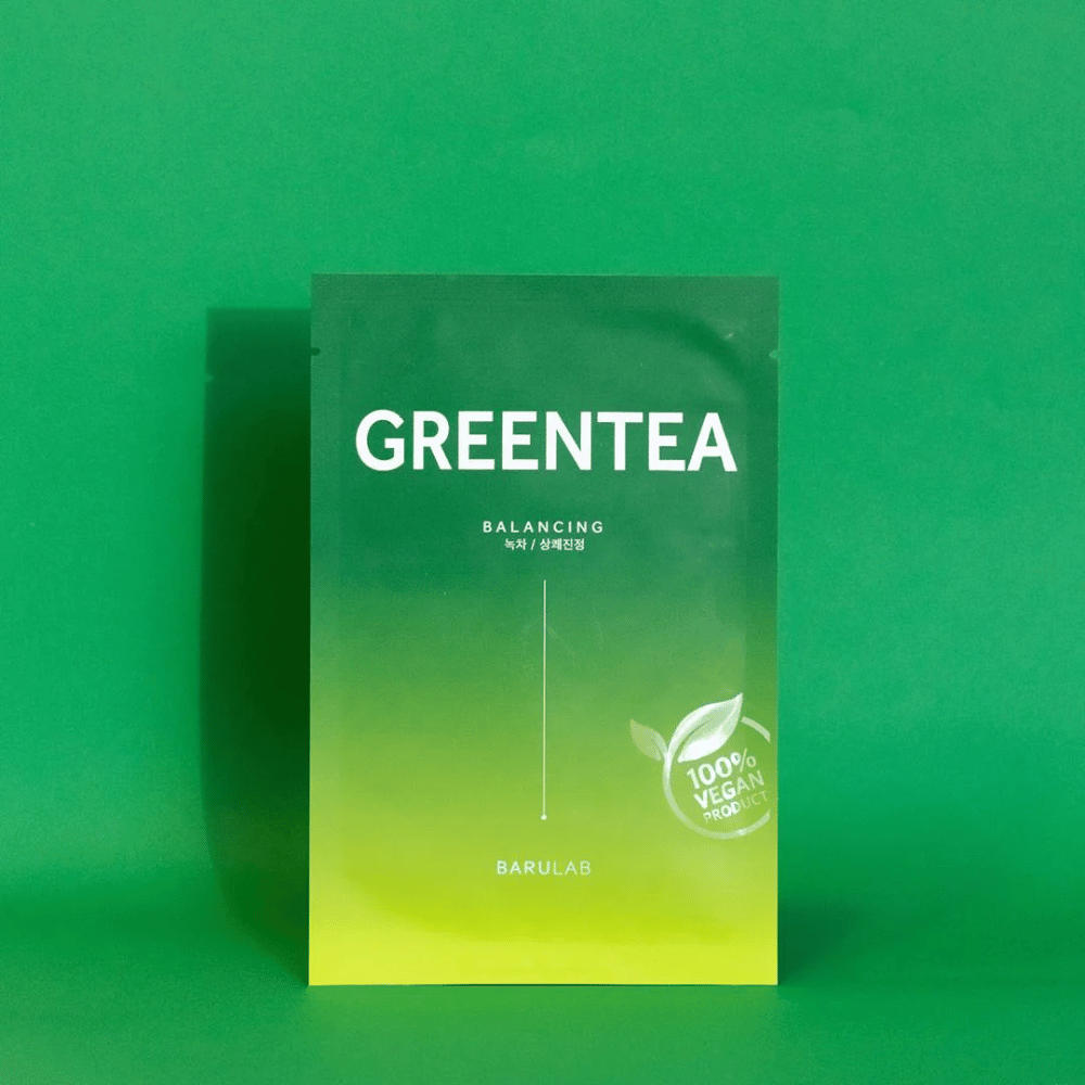 Un emballage de BARULAB pour un masque "GREENTEA Balancing", marqué comme "100% Vegan Product". La couleur de l'emballage passe du vert foncé en haut au vert plus clair en bas, sur un fond vert uni.