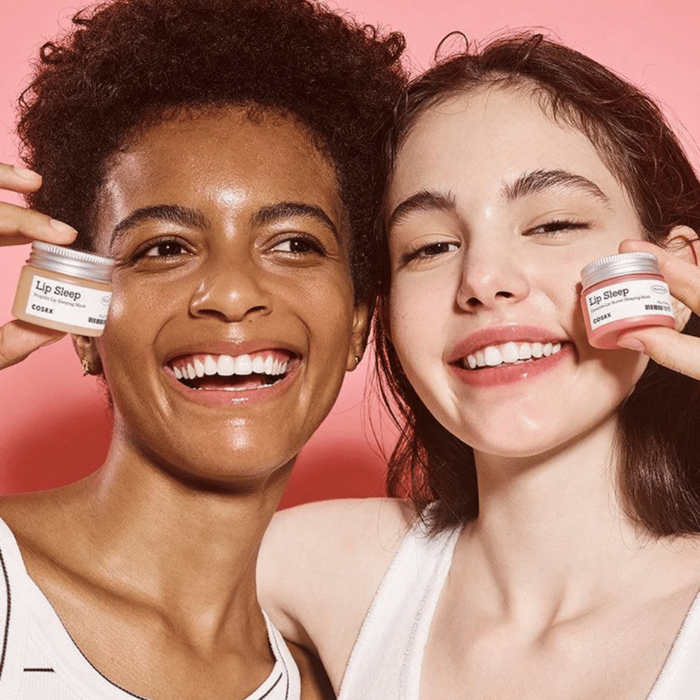 Deux personnes sourient et tiennent des pots COSRX Lip Sleep. L'image transmet des lèvres douces, hydratées et l'effet naturel éclatant du produit.