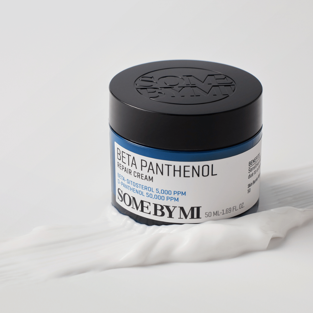 SOME BY MI Beta Panthenol Repair Cream dans un pot bleu placé sur une texture de crème – crème apaisante et hydratante.
