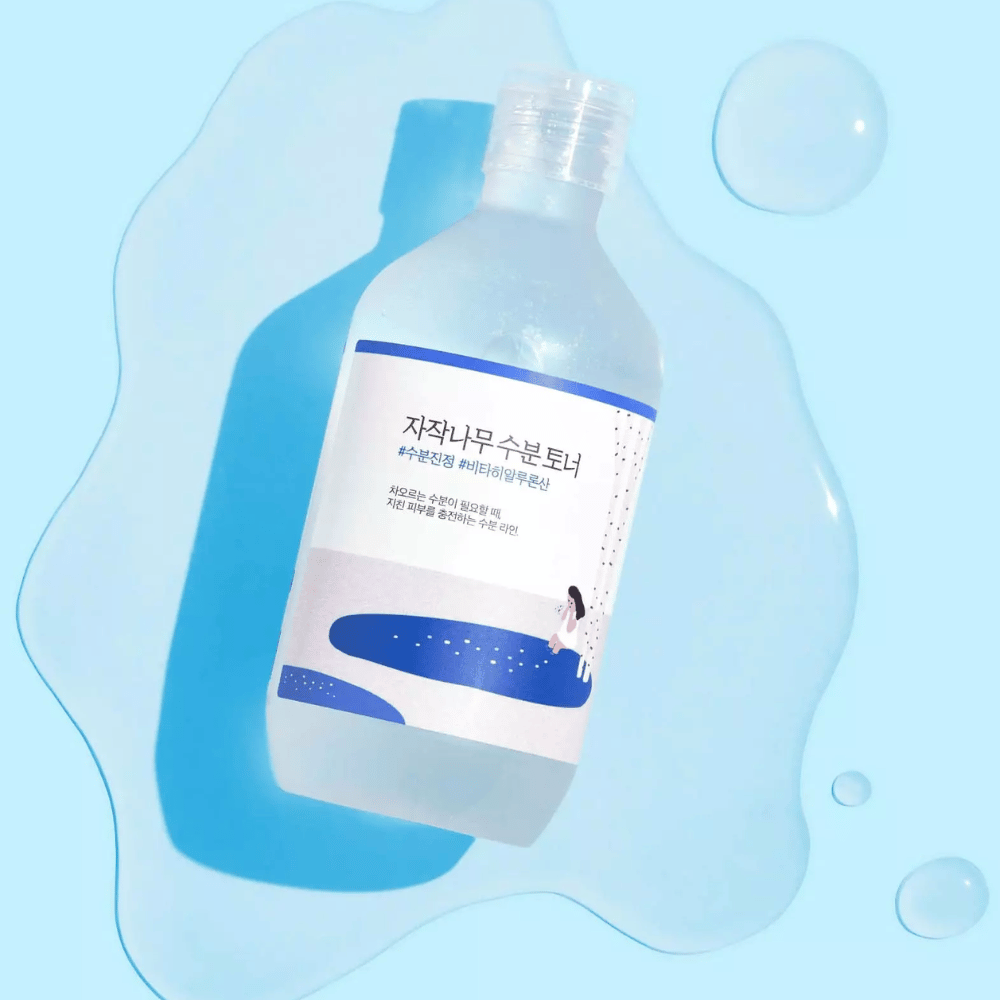 Le flacon est incliné dans un liquide semblable à de l’eau avec des gouttes tout autour sur fond bleu