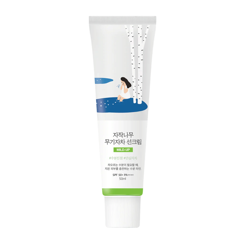 Birch Juice Moisturizing Mild Up Sunscreen SPF 50+ PA++++ – crème solaire en tube blanc avec illustration de bouleaux et fille près du cours d'eau, 50 ml.