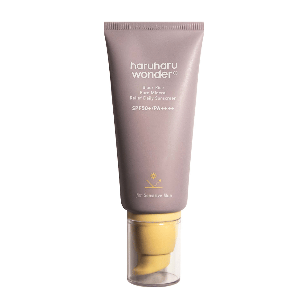 Un tube violet avec Haruharu Wonder Black Rice Pure Mineral Relief Daily Sunscreen SPF 50+ PA++++. Le tube a un bouchon transparent et un texte qui décrit le haut niveau de protection de la crème solaire, spécialement adapté pour la peau sensible.