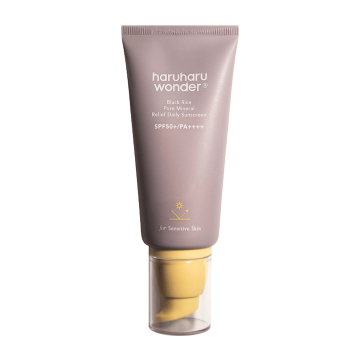 Un tube violet avec Haruharu Wonder Black Rice Pure Mineral Relief Daily Sunscreen SPF 50+ PA++++. Le tube a un bouchon transparent et un texte qui décrit le haut niveau de protection de la crème solaire, spécialement adapté pour la peau sensible.