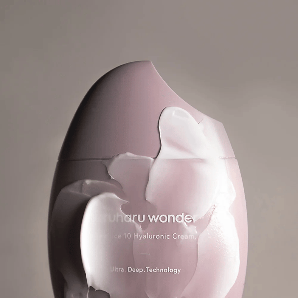 L'image montre un pot avec "Haruharu Wonder Black Rice 10 Hyaluronic Cream", qui est partiellement couvert d'une crème épaisse et transparente. Le texte sur l'image suggère l'utilisation d'une technologie avancée pour une hydratation profonde de la peau. Le design est moderne et minimaliste.