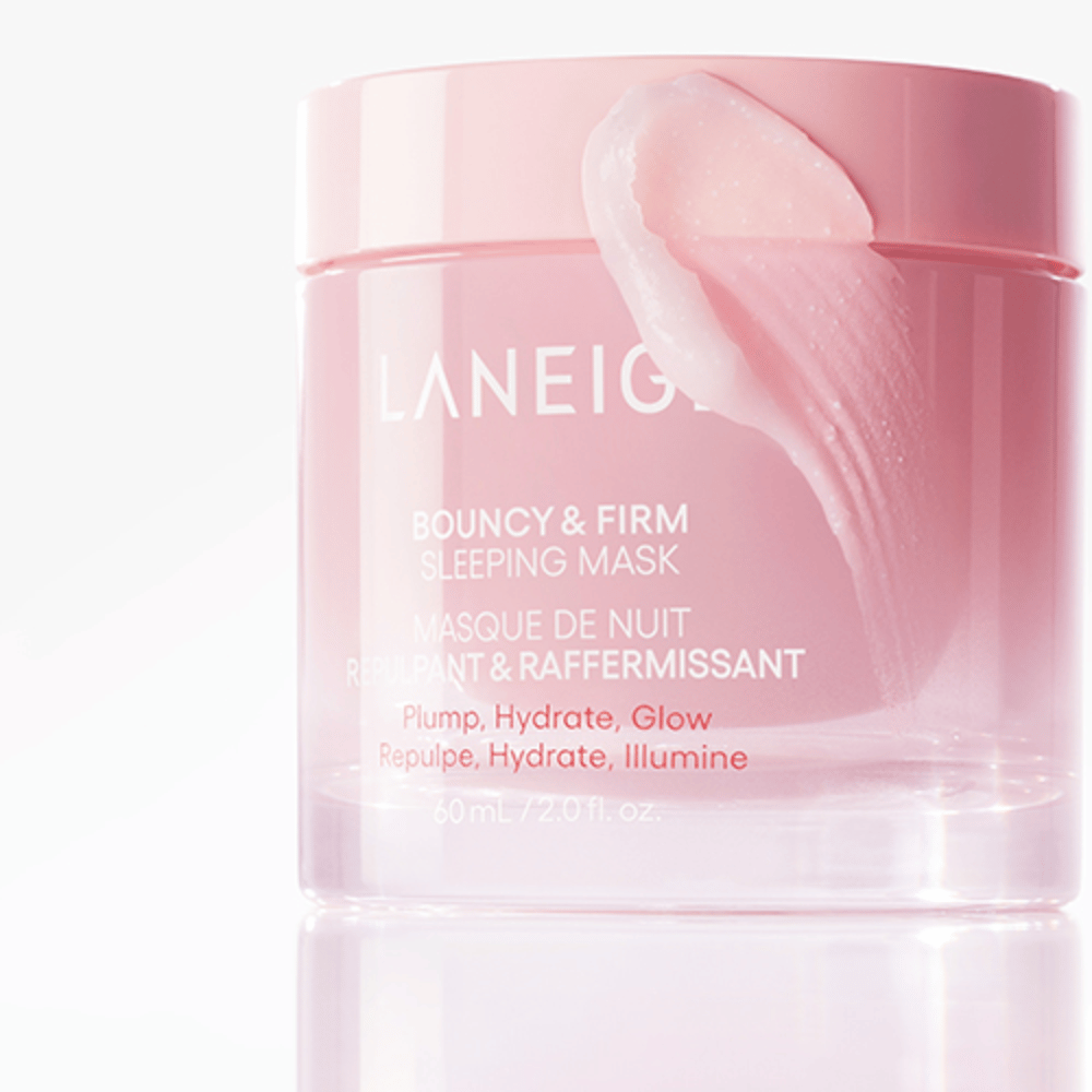 Gros plan sur Laneige Bouncy & Firm Sleeping Mask dans un pot rose, avec une partie du masque appliquée sur le bord du couvercle. Le produit est destiné à donner du volume, hydrater et illuminer. Le pot contient 60 ml et porte le texte "Plump, Hydrate, Glow."