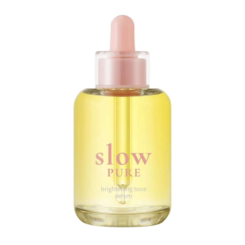 Slow Pure Brightening Tone Serum dans une bouteille en verre transparent avec une pipette, rempli de sérum jaune éclatant.