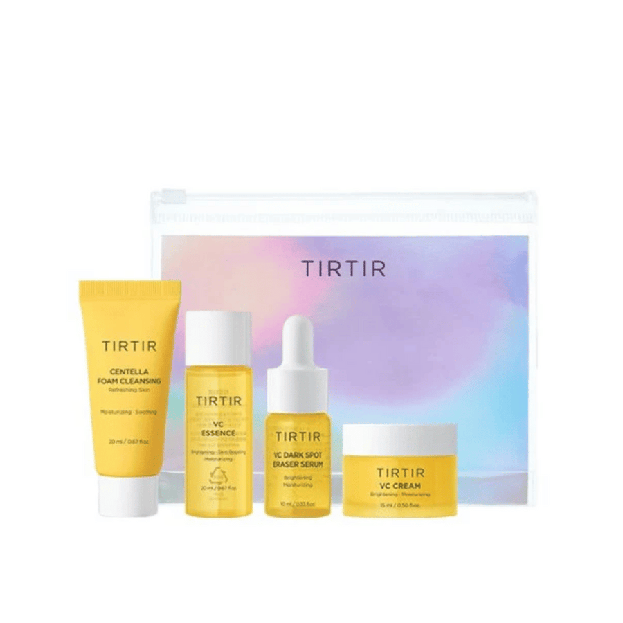 Un kit avec des produits de soin de la peau Tirtir est présenté dans un sac transparent. Le kit contient "Centella Foam Cleansing" dans un tube jaune, "VC Essence" dans une bouteille transparente, "VC Dark Spot Eraser Serum" dans un flacon compte-gouttes jaune et "VC Cream" dans un pot de crème jaune. Les produits sont conçus pour donner une peau plus lumineuse et plus hydratée.
