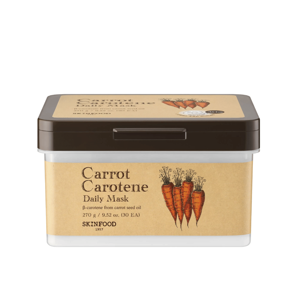 Un emballage "Carrot Carotene Daily Mask" de SKINFOOD, contenant 30 masques faciaux. Le produit est enrichi en β-carotène provenant de l'huile de graines de carotte et est conçu pour un usage quotidien. L'emballage est robuste avec une étiquette d'inspiration vintage qui met en valeur les carottes comme ingrédient principal.