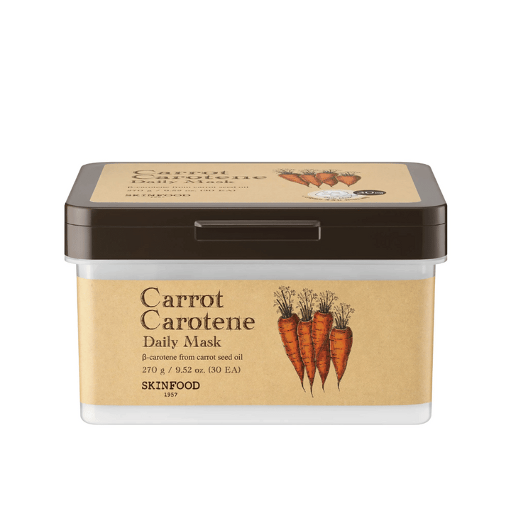 Un emballage "Carrot Carotene Daily Mask" de SKINFOOD, contenant 30 masques faciaux. Le produit est enrichi en β-carotène provenant de l'huile de graines de carotte et est conçu pour un usage quotidien. L'emballage est robuste avec une étiquette d'inspiration vintage qui met en valeur les carottes comme ingrédient principal.