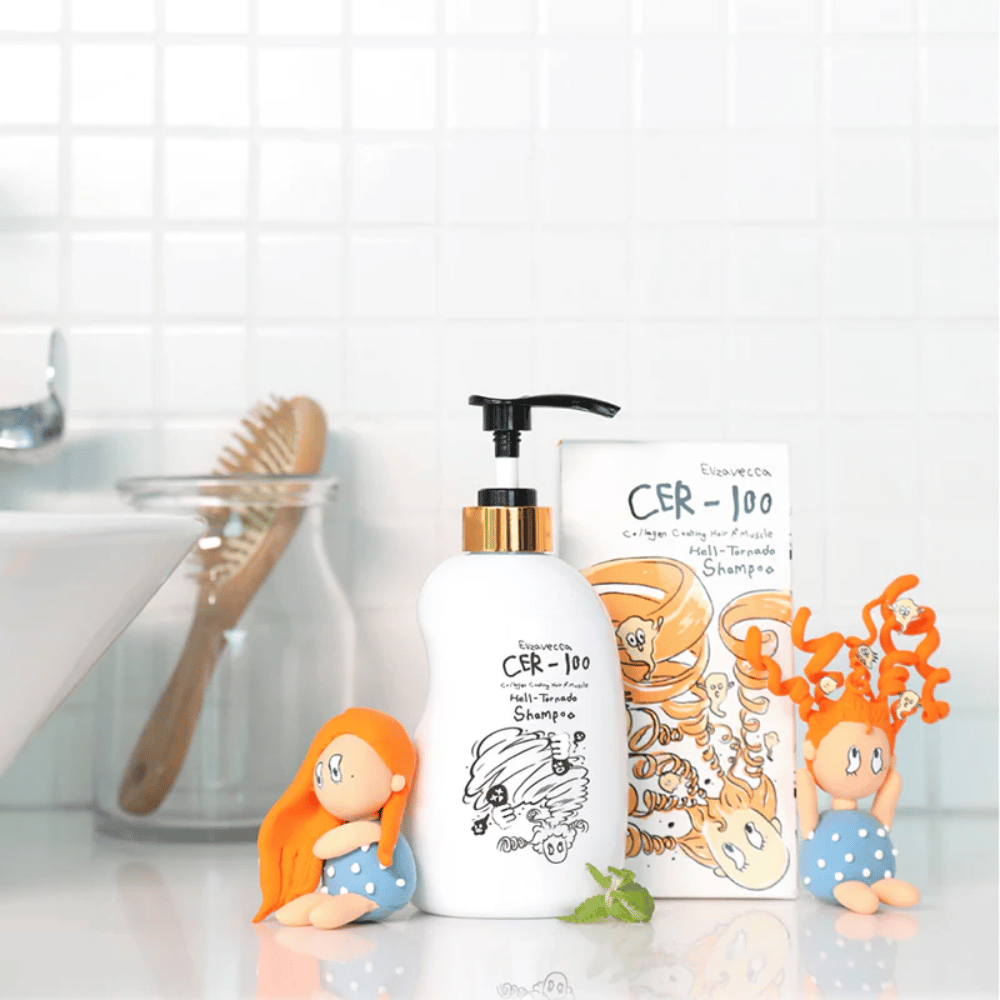 Elizavecca CER-100 Shampoo et sa boîte sont présentés dans un environnement de salle de bain à côté d’une brosse à cheveux et de figurines décoratives. L’image transmet une routine capillaire quotidienne et l’utilisation du produit à la maison.