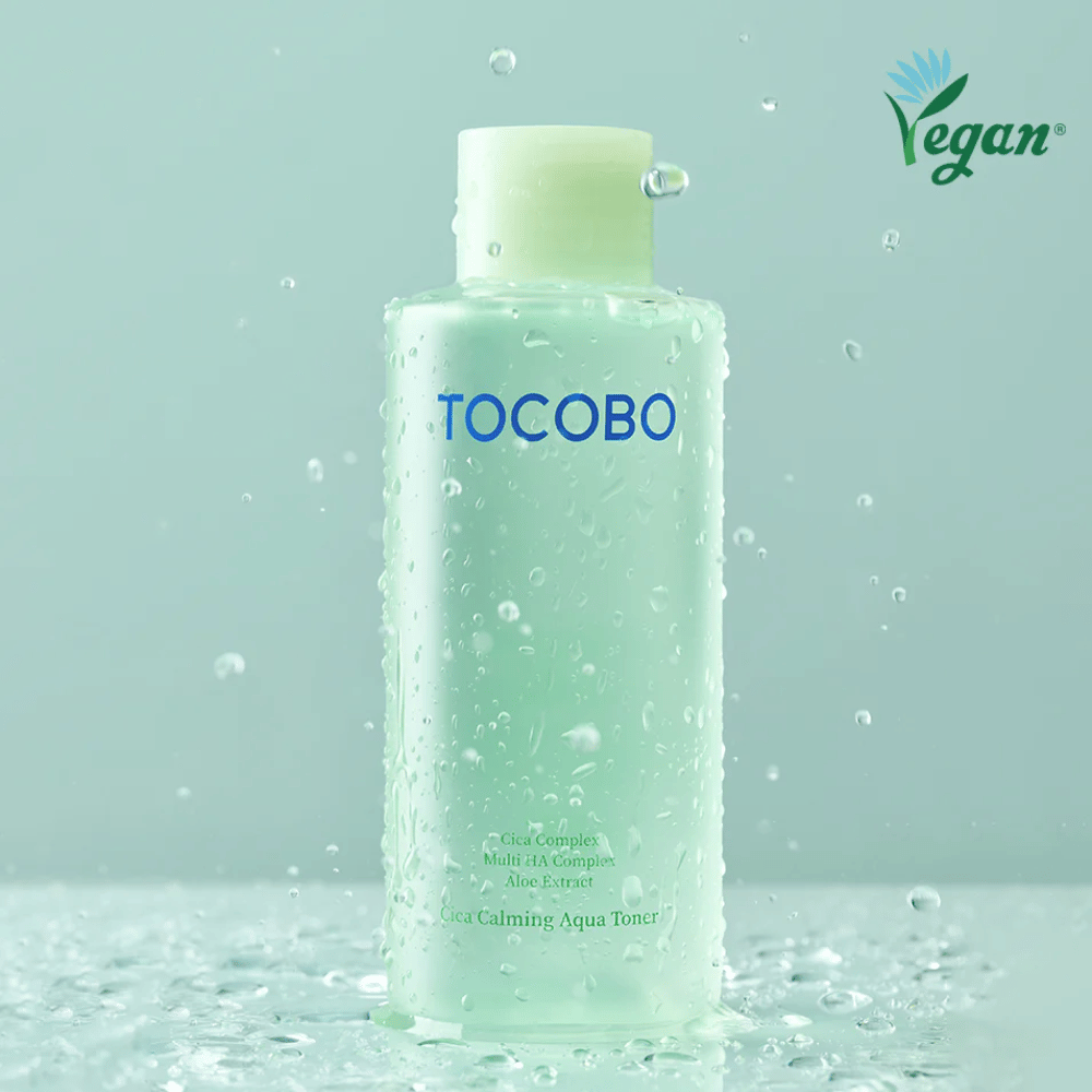 Image produit de TOCOBO Cica Calming Aqua Toner entouré de gouttes d’eau qui soulignent les propriétés hydratantes et apaisantes du toner pour les peaux sensibles.