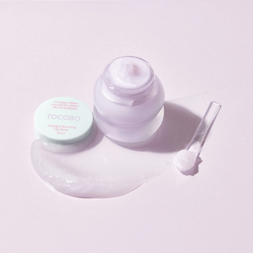 Pot ouvert TOCOBO Collagen Boosting Lip Mask avec une spatule et une crème violette répandue sur un fond violet clair.