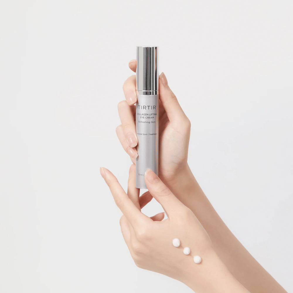Mains tenant un tube avec TIRTIR Collagen Lifting Eye Cream, avec le produit pressé sur le dos de la main.