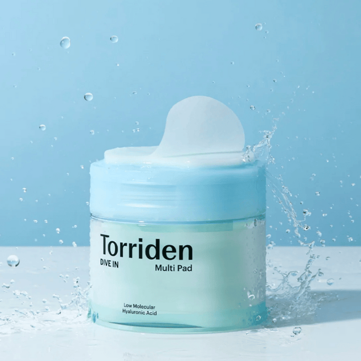 Torriden "DIVE IN Multi Pad" avec des gouttes d'eau en suspension sur fond bleu.