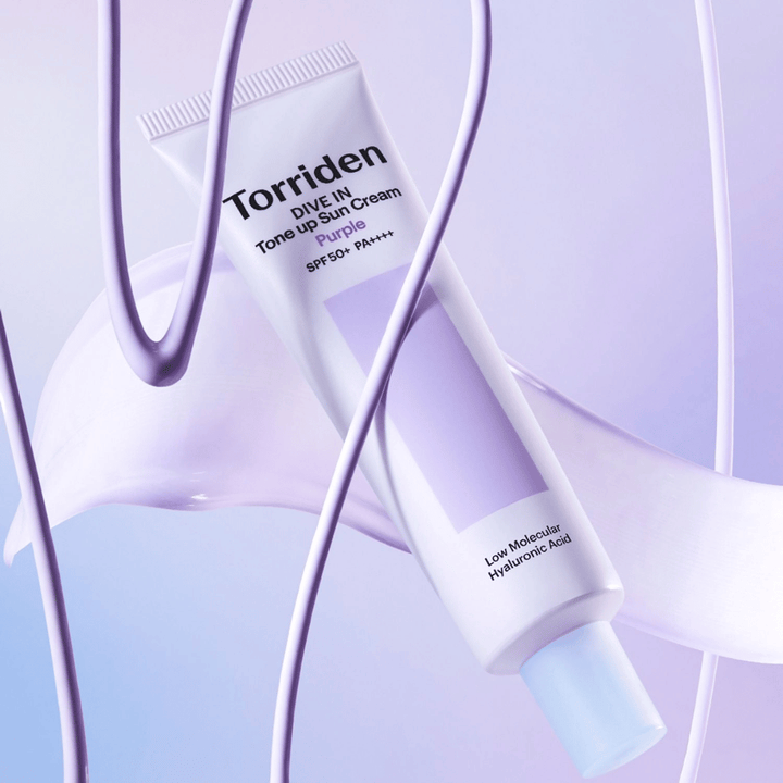 Torriden DIVE IN Tone Up Sun Cream Purple SPF50+ PA++++ présenté dans un décor produit créatif avec des détails violets qui mettent en valeur la formule hydratante.