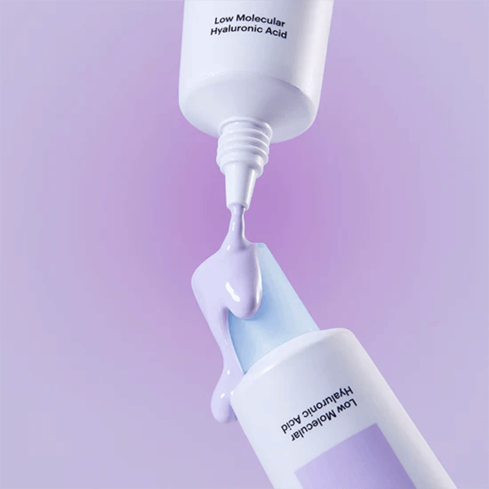Gros plan sur Torriden DIVE IN Tone Up Sun Cream Purple où la crème violette est appliquée depuis le tube pour illustrer la consistance du produit.