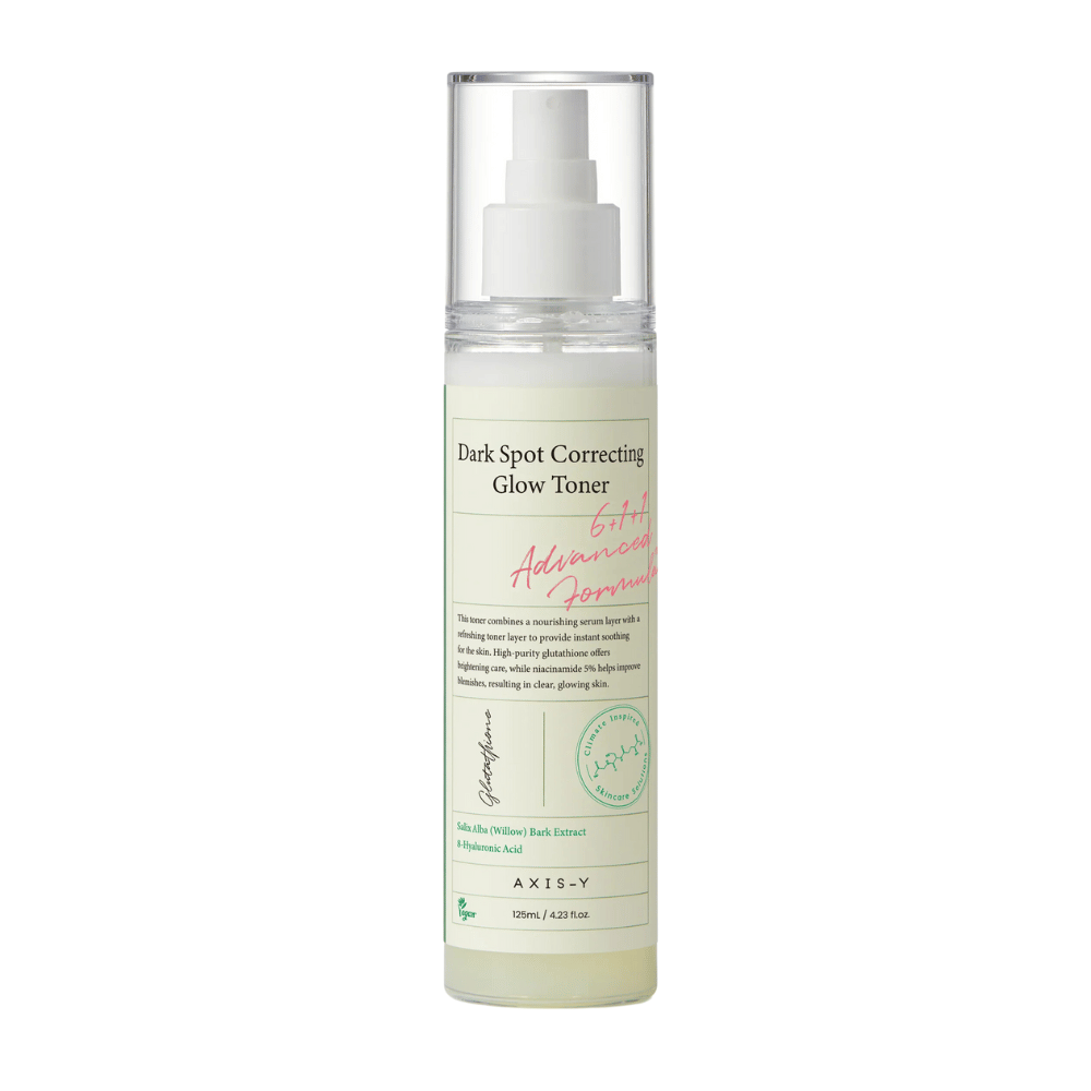 Une image d'une bouteille du produit "AXIS-Y Dark Spot Correcting Glow Toner". La bouteille est transparente avec une étiquette blanche et du texte en noir et vert. Le produit est un toner sous forme de spray, et la bouteille contient 125 ml (4,23 fl. oz). L'étiquette mentionne des ingrédients clés tels que l'extrait d'écorce de saule et l'acide hyaluronique.