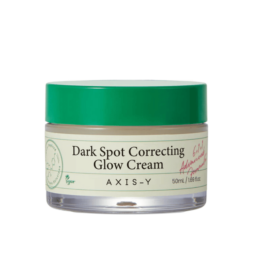 Un pot de "AXIS-Y Dark Spot Correcting Glow Cream". Cette crème est destinée à corriger les taches sombres et à donner de l'éclat à la peau. L'emballage est élégant avec un fond transparent et un couvercle vert accrocheur.