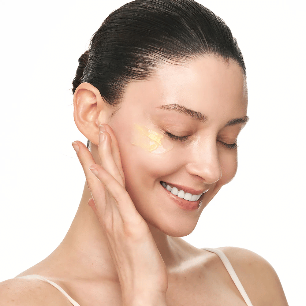 Une personne masse Sungboon Editor Deep Collagen Retinol Capsule Cream sur la joue. Le produit offre de l'éclat, de la fermeté et une hydratation durable.