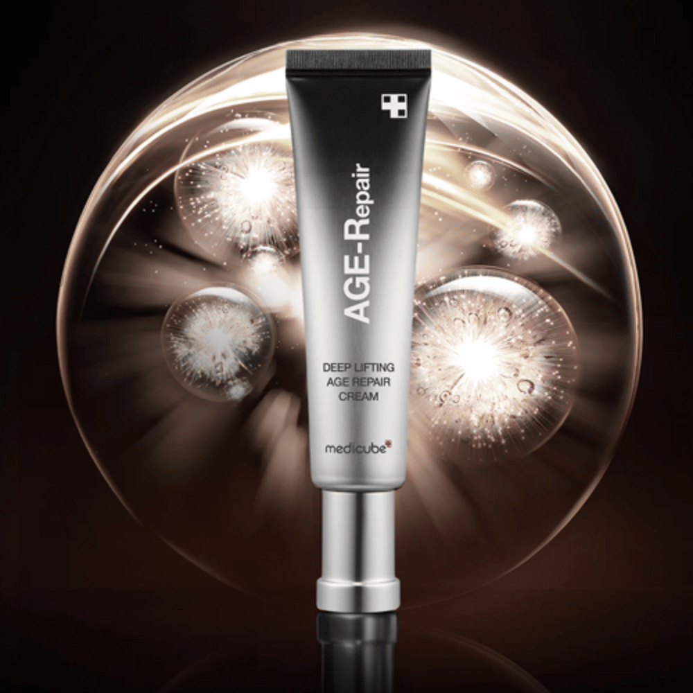 Medicube Deep Lifting Age Repair Cream en tube argenté sur fond avec effets lumineux, symbolise l'anti-âge et le renouvellement de la peau.
