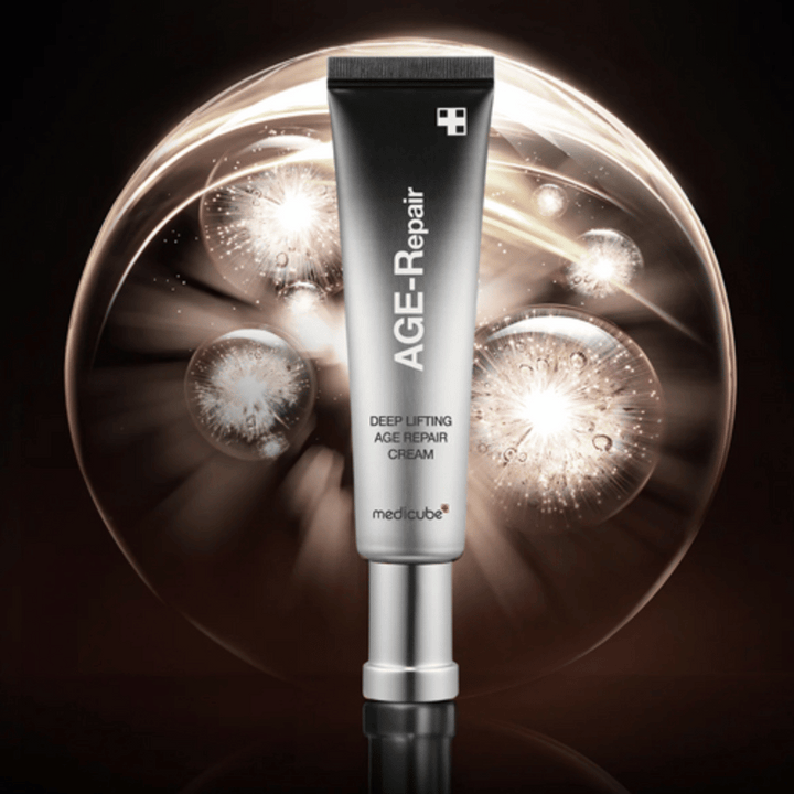 Medicube Deep Lifting Age Repair Cream en tube argenté sur fond avec effets lumineux, symbolise l'anti-âge et le renouvellement de la peau.
