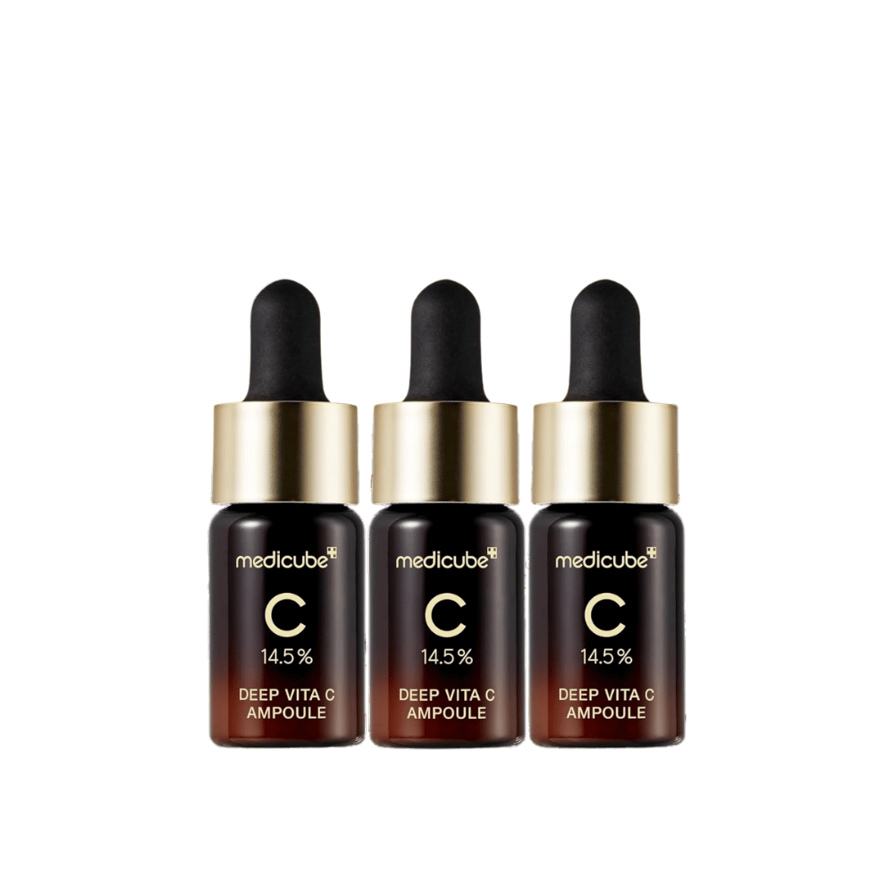 Trois flacons de Medicube Deep Vita C Ampoule, avec 14,5 % de vitamine C, disposés en ligne. Les flacons ont un design élégant avec une base brun foncé et un bouchon doré. Parfait pour un teint plus lumineux et une texture de peau plus uniforme.