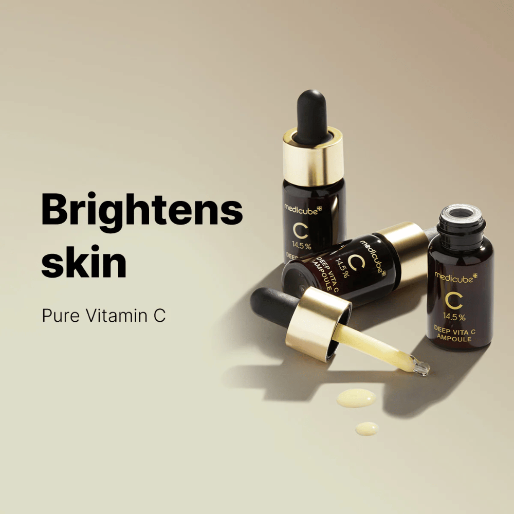 Medicube Deep Vita C Ampoule avec 14,5 % de vitamine C, présenté dans des flacons élégants avec des pipettes dorées. Le produit est conçu pour éclaircir le teint et donner un éclat radieux. Le texte "Brightens skin" et "Pure Vitamin C" renforce le message.