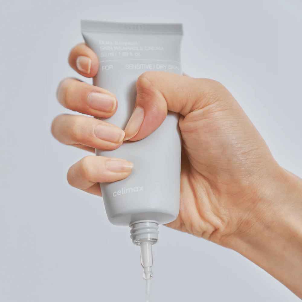 Main appliquant Celimax Dual Barrier Skin Wearable Cream, crème visage renforçant la barrière pour la peau sensible et sèche qui offre une hydratation durable et protège la barrière cutanée.