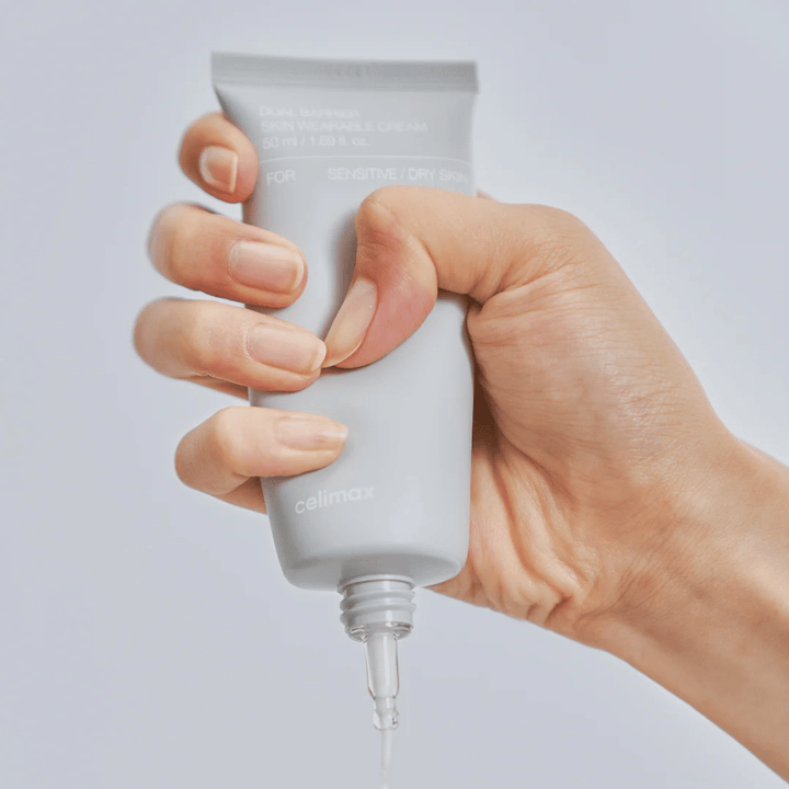 Main appliquant Celimax Dual Barrier Skin Wearable Cream, crème visage renforçant la barrière pour la peau sensible et sèche qui offre une hydratation durable et protège la barrière cutanée.