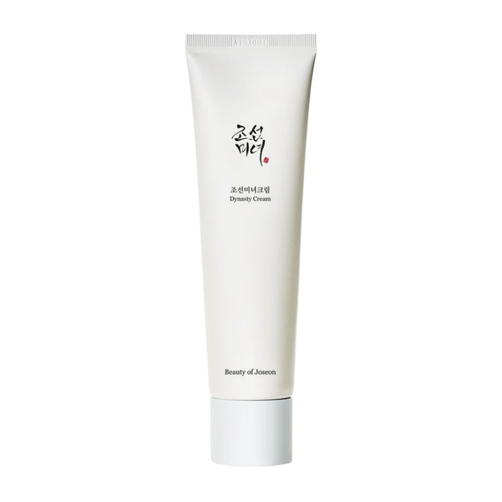 L'image montre un tube de "Beauty of Joseon Dynasty Cream". Le tube blanc et élancé a des éléments de design minimalistes, y compris un texte élégant en noir et rouge. Ce produit de soin de la peau promet de nourrir et de revitaliser la peau, reflétant les secrets de beauté historiques de la dynastie Joseon.