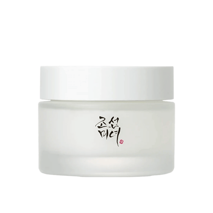 L'image montre un pot "Beauty of Joseon Dynasty Cream". L'emballage est en verre dépoli avec un simple couvercle blanc, élégamment décoré de calligraphie coréenne traditionnelle en noir. Le produit est destiné à offrir des soins de la peau nourrissants inspirés des anciennes routines de beauté coréennes.