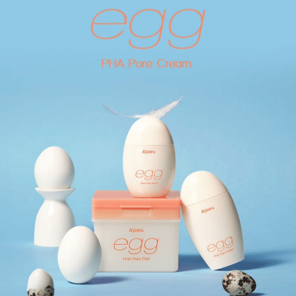 A'pieu Egg PHA Pore-série - des produits en forme d'œuf comme le sérum, la crème et les pads, élégamment arrangés sur un fond bleu avec des œufs et des plumes symbolisant un soin de la peau doux.