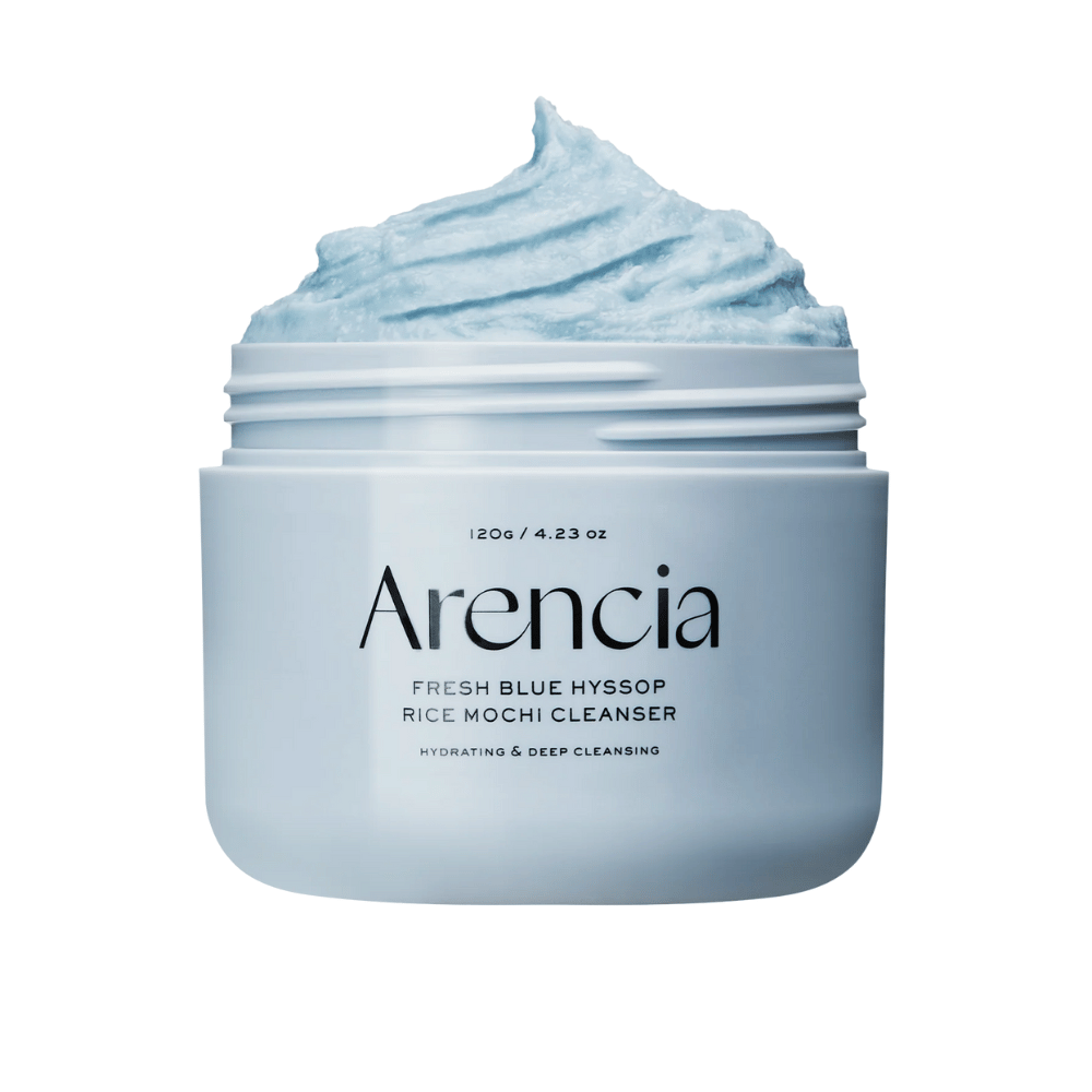 Gros plan sur un pot ouvert Arencia Fresh Blue Hyssop Rice Mochi Cleanser. La crème nettoyante bleue a une texture aérée et fouettée et remplit le haut du pot.