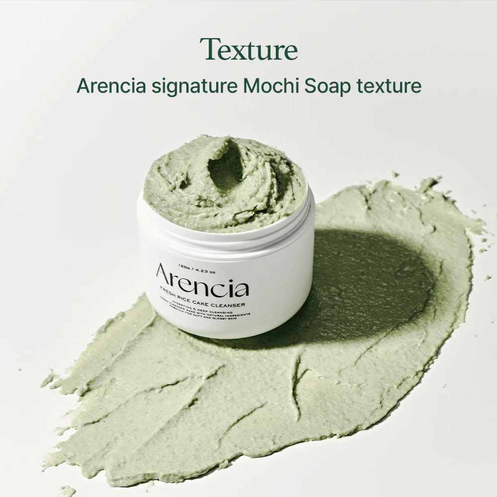 Arencia Fresh Rice Cake Cleanser dans un pot ouvert avec une texture crémeuse verte semblable à du mochi étalée autour du pot sur un fond blanc.